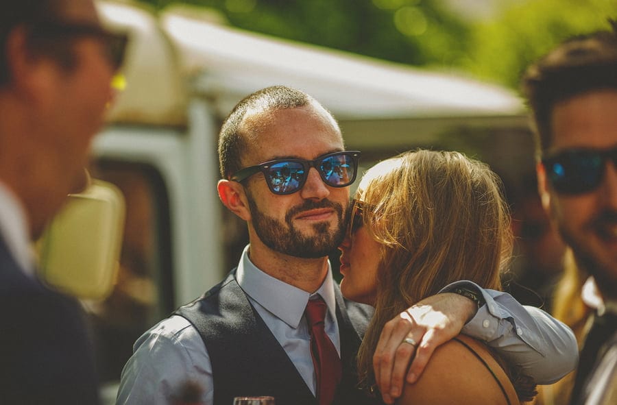 A husband and wife embrace each other outside the tipi