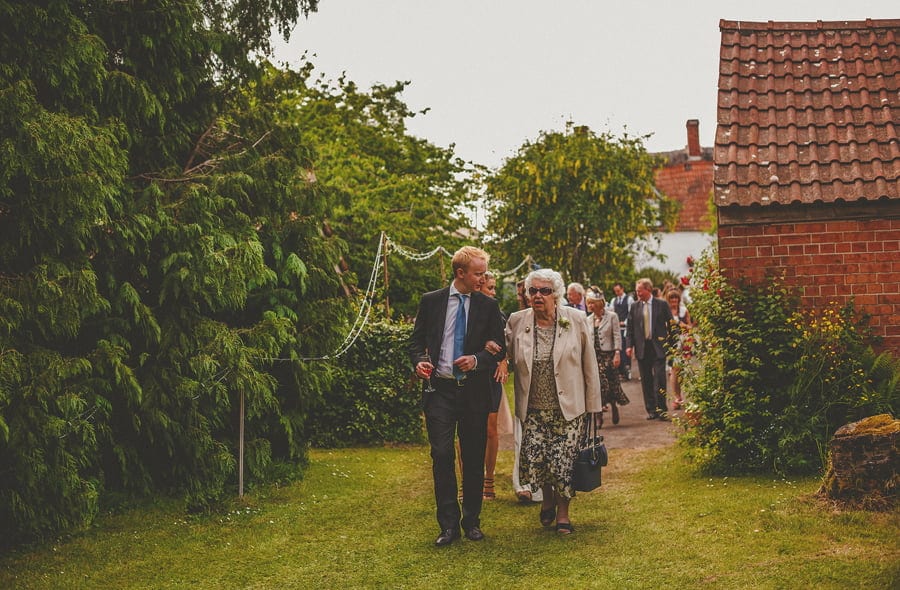 The family of the bride and groom make their way into the back garden
