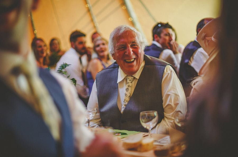 The grooms father laughs at his sons speech