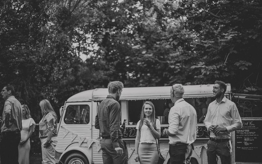 Wedding guests enjoy a drink and conversation on the lawn