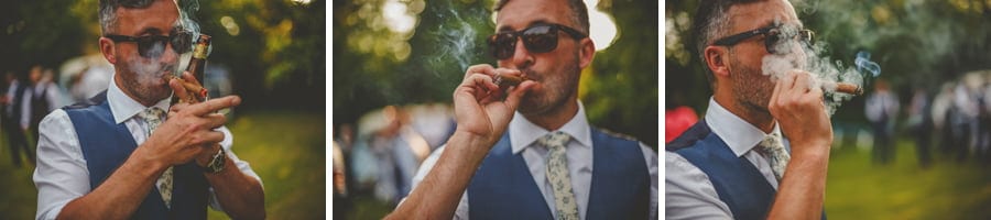 The groom lights up his cigar in the back garden of his parents house