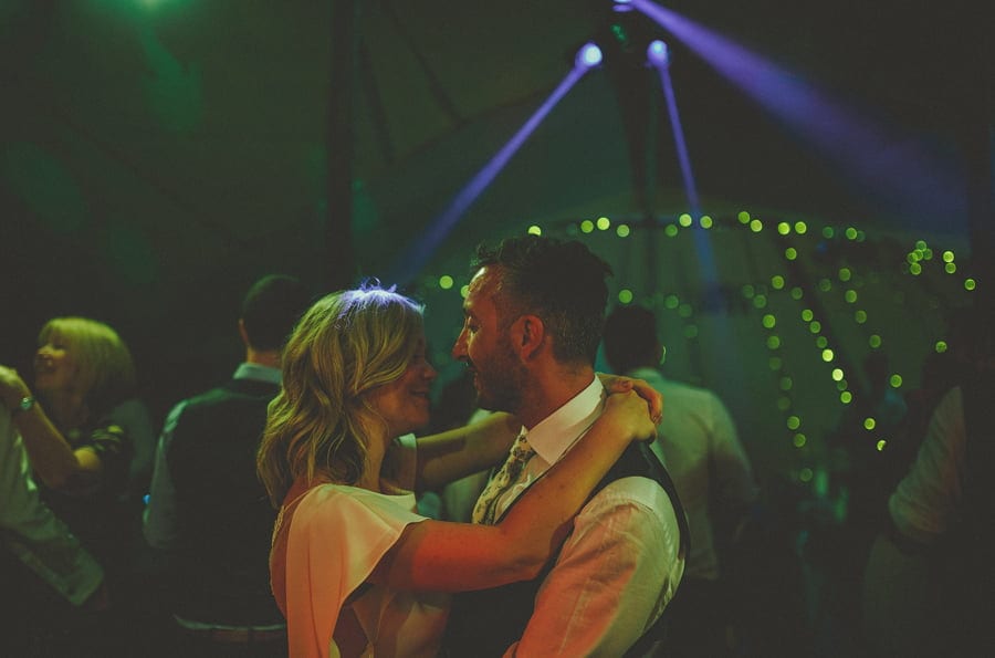 The bride and groom look and embrace each other on the dancefloor of the tipi