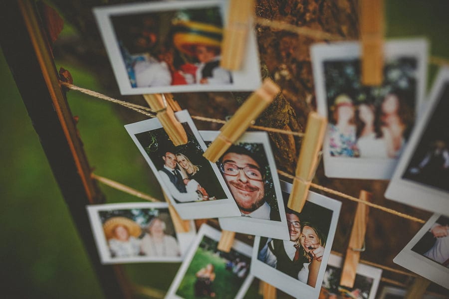 Polaroid photographs hang from pieces of string