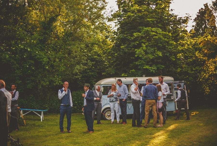 Wedding guests congregate on the lawn next to the cocktail van