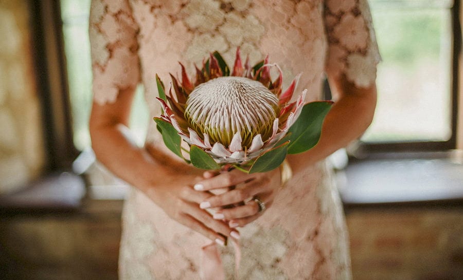 A bridesmaid holds a large flower in both hands