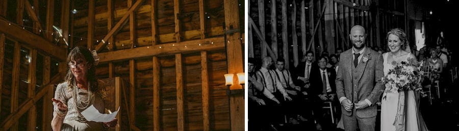 The bride and groom stand next to each other as they listen to a reading by the bride's mother in the old barn during the wedding ceremony
