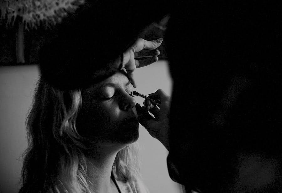 The bride has mascara applied to her eye lids