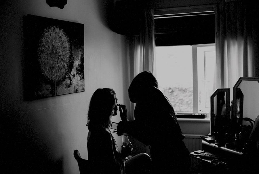 The make up artist applies make up onto the brides face