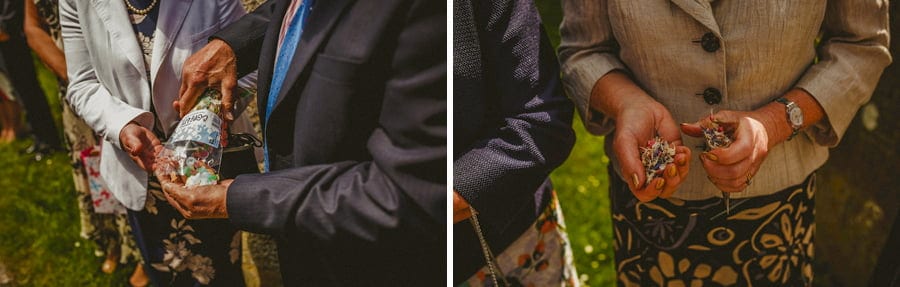 Wedding guests hold confetti and wait for the bride and groom to leave the church