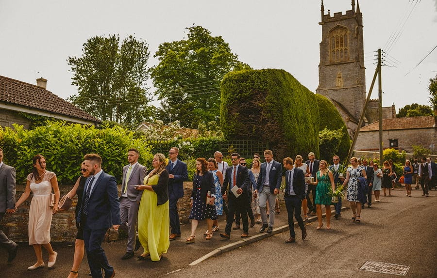 Wedding guests leaving the church and walking down the street