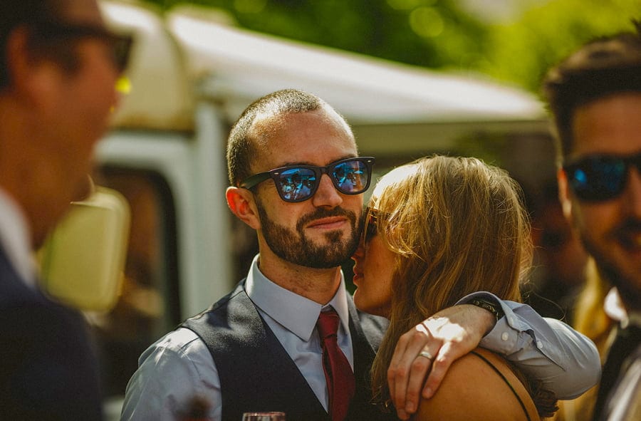 A husband and wife embrace each other outside the tipi