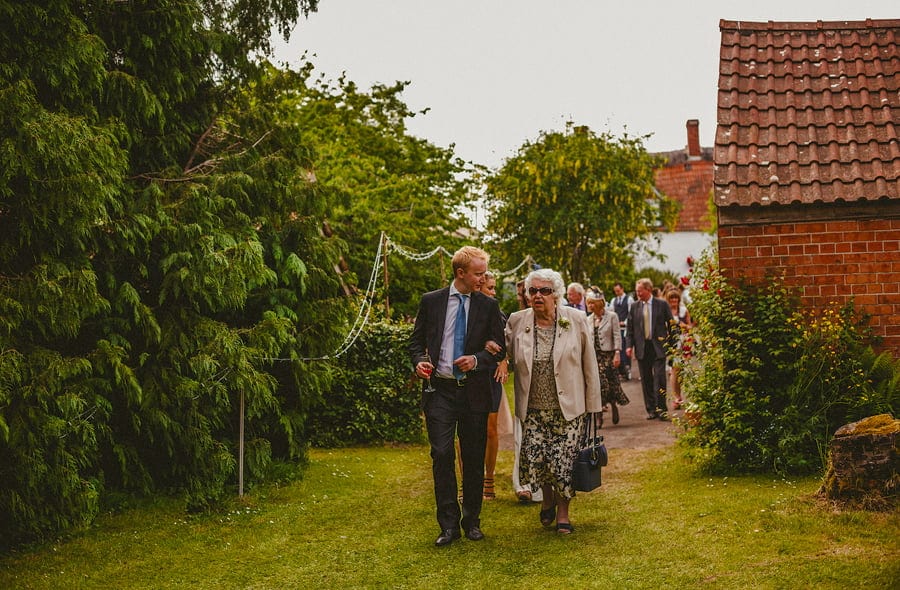 The family of the bride and groom make their way into the back garden