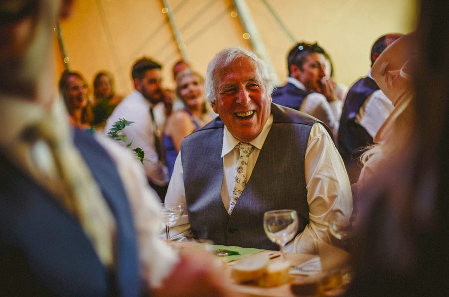 The grooms father laughs at his sons speech