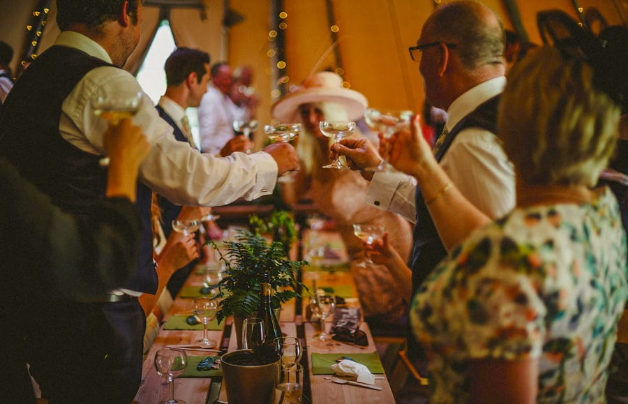 Wedding guests raise their glasses in the tipi