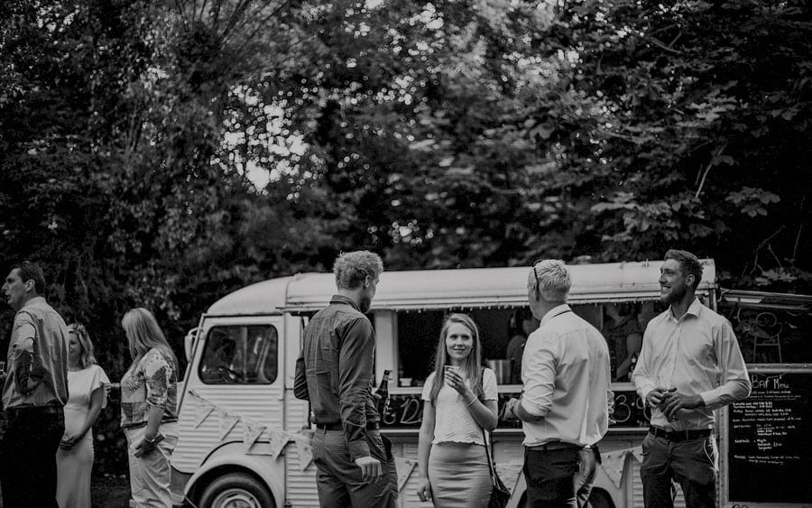 Wedding guests enjoy a drink and conversation on the lawn
