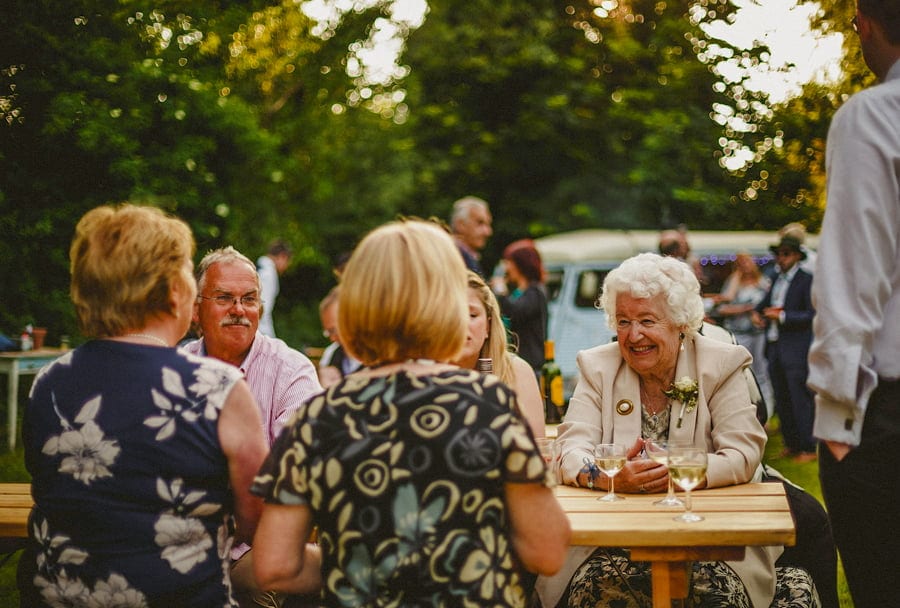 The wedding party enjoy drinks in the garden
