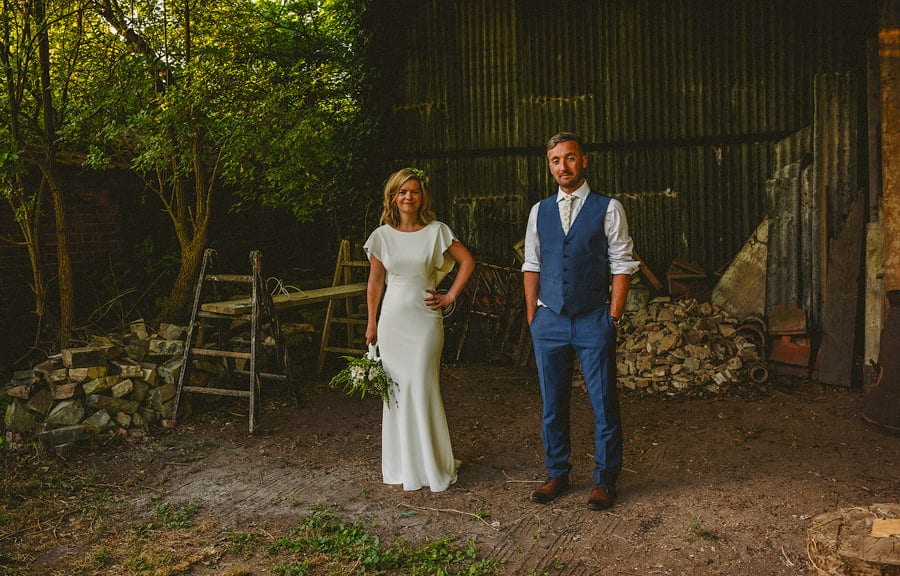 Claire and Dan stand in front of the open barn and pose for a photograph