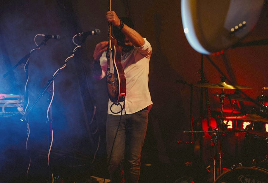 The guitarist playing solo in the tipi