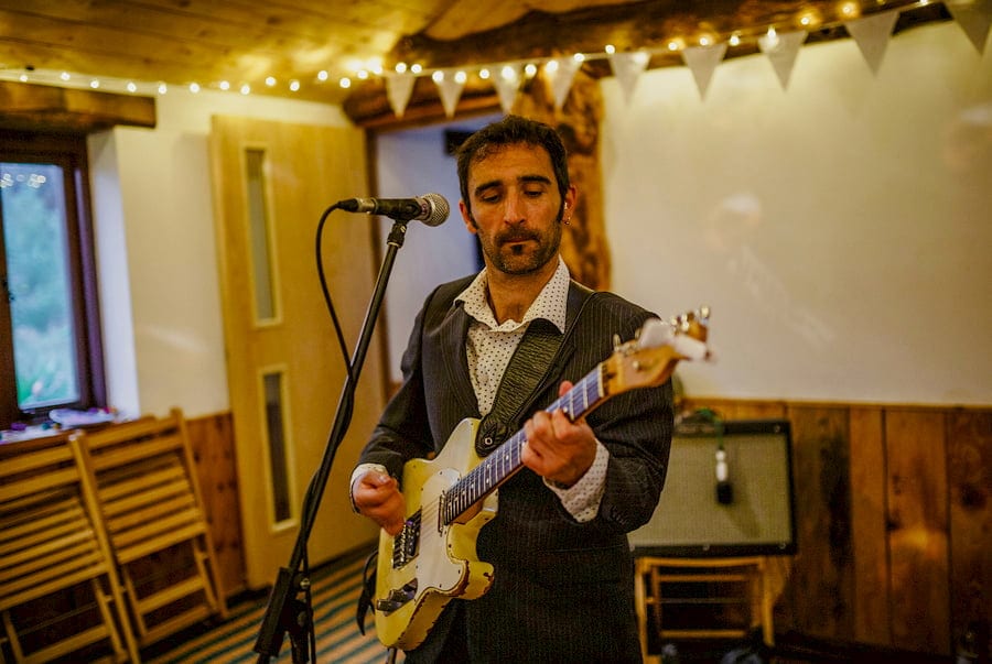 The guitarist in the wedding band plays his guitar