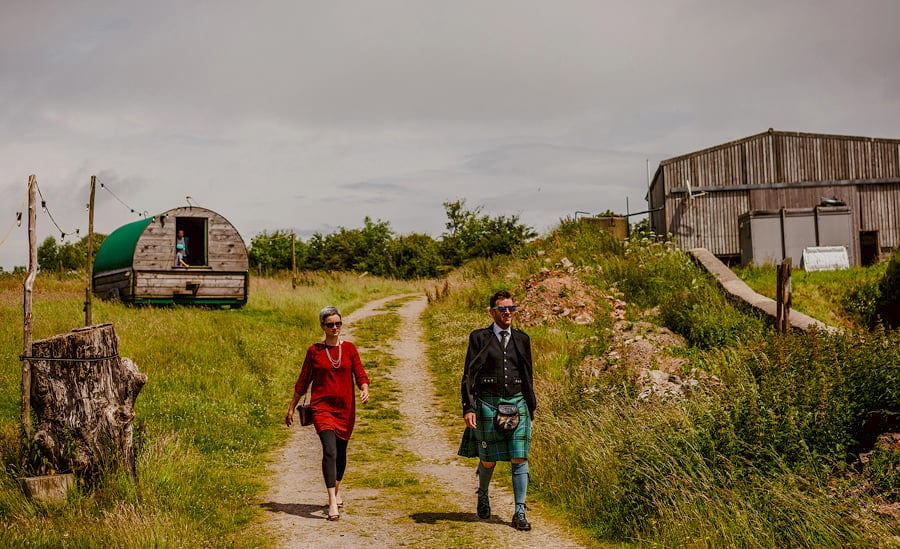Wedding guests walk down to the outdoor ceremony at Fernhill Farm