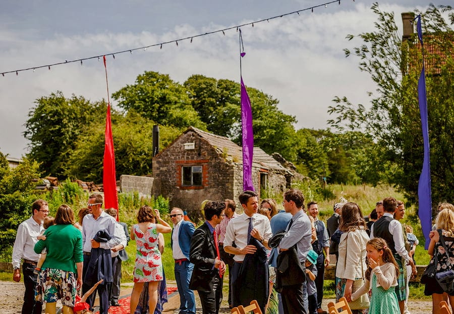 Wedding guests talk to each other in the courtyard at Fernhill Farm