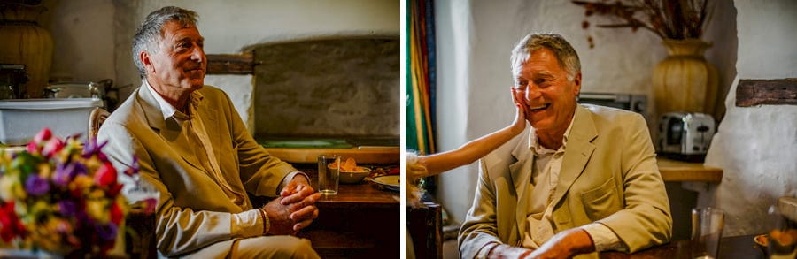 The father of the bride sits in the kitchen of the cottage at Fernhill Farm