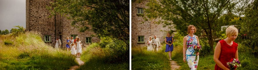 Bridesmaids walk away from the cottage towards the outdoor wedding ceremony at Fernhill Farm
