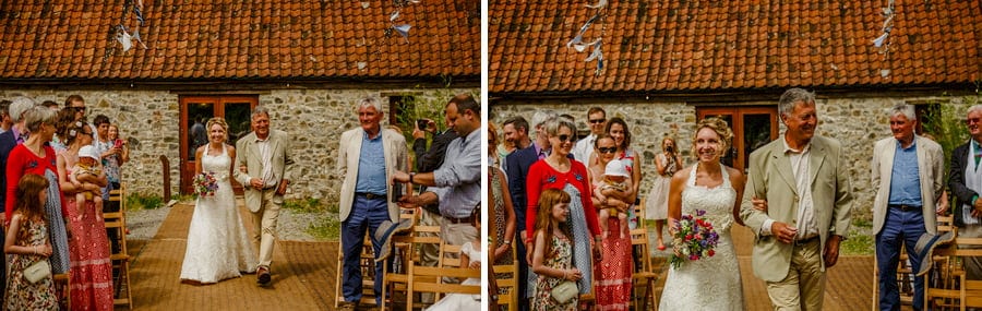 The bride and her father walk towards the outdoor wedding ceremony in the courtyard at Fernhill Farm