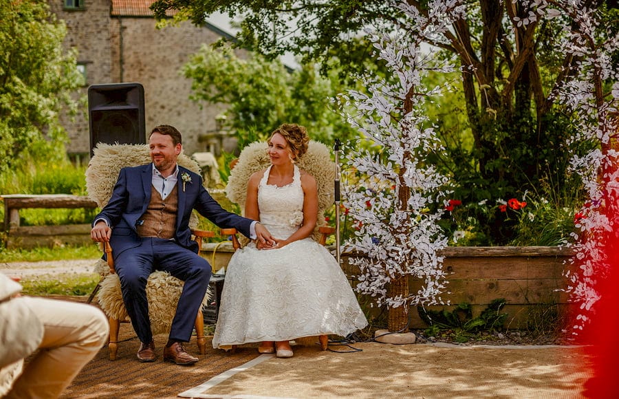 The bride and groom sit next to each other during the wedding ceremony