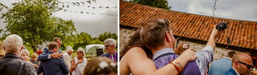 A wedding guest takes a picture of himself and his wife