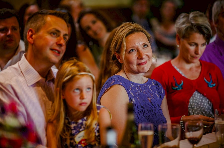 Wedding guests sat at the table listening to the speeches in the barn