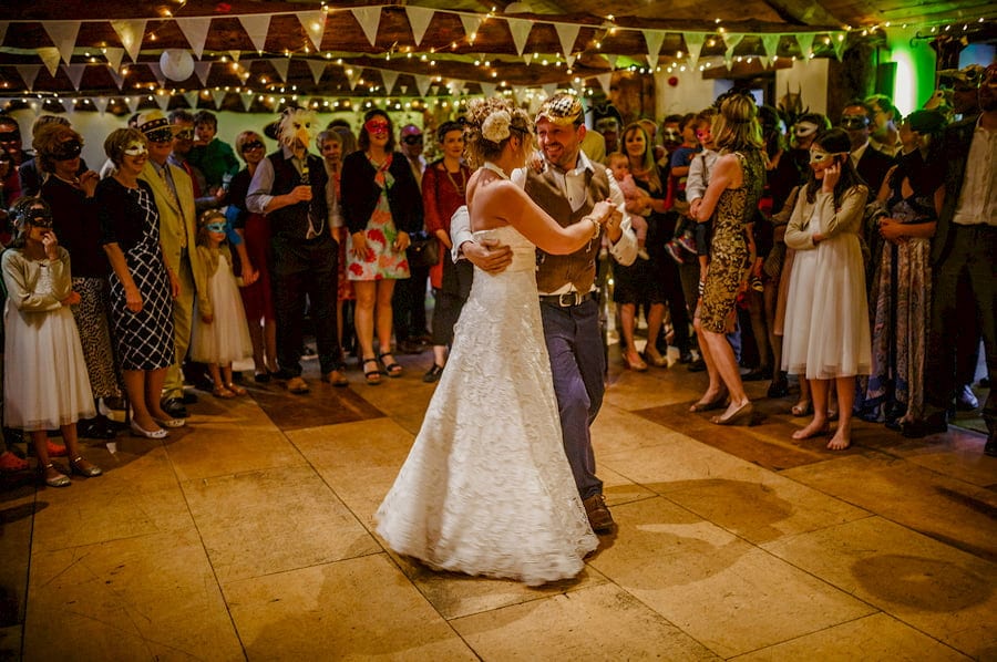 The bride and groom hold each other and dance on the dancefloor in the barn at Fernhill Farm