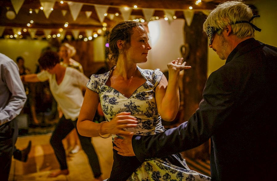 A lady dances with a man on the dancefloor in the barn at Fernhill Farm