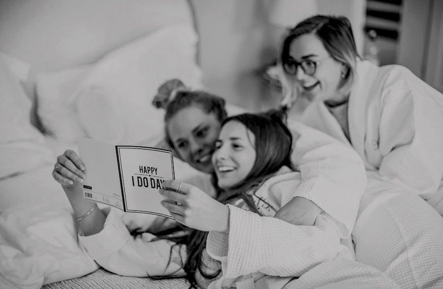Bridesmaids reading wedding cards on the bed