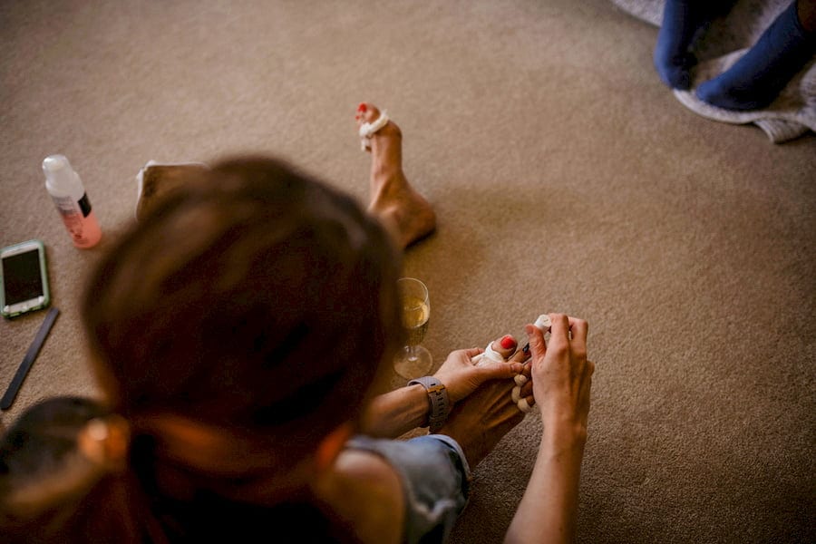 A wedding guest paints her toe nails