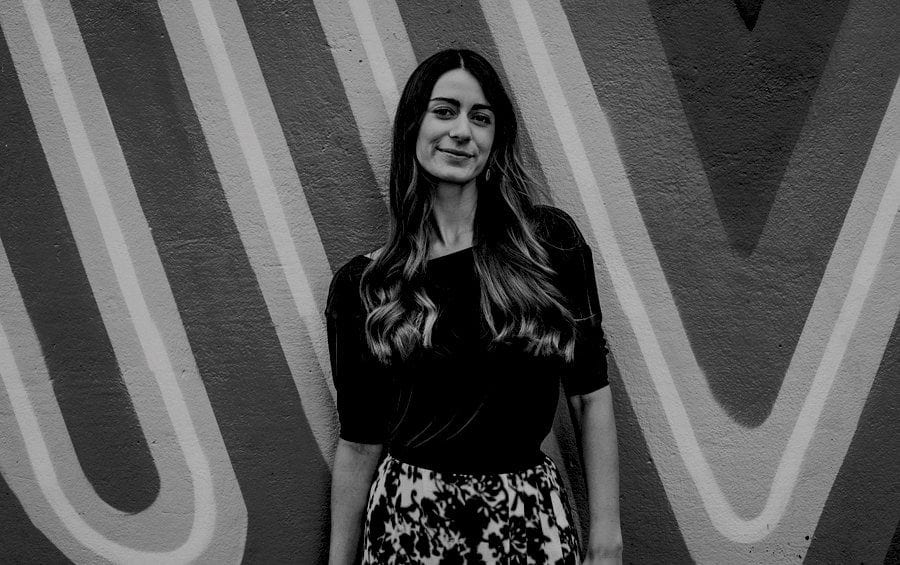 A lady poses for a photograph and looks straight at the camera