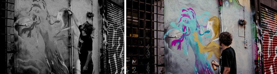 A man paints a wall with a canister of spray paint