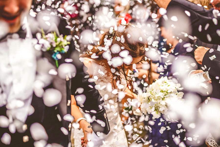 Confetti fall onto the bride and groom