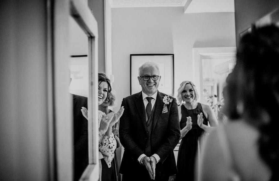 The bride's father and his family greet the bride as she walks towards them in her wedding dress