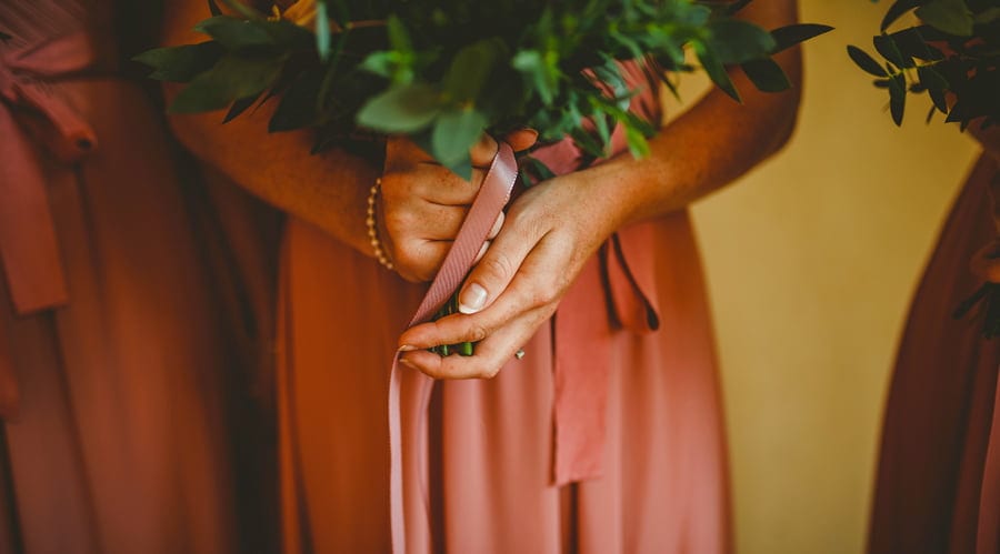 A bridesmaid holds her bouquet of flowers with both hands