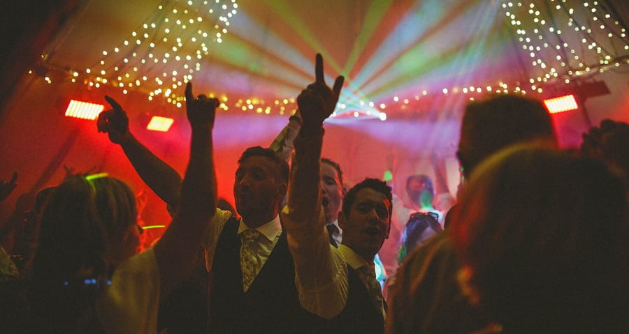 The wedding guests dancing on the dancefloor of the marquee