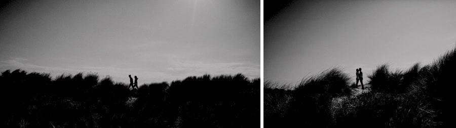 The man and lady walk along the sand dunes in the distance at West Wittering beach in West Sussex