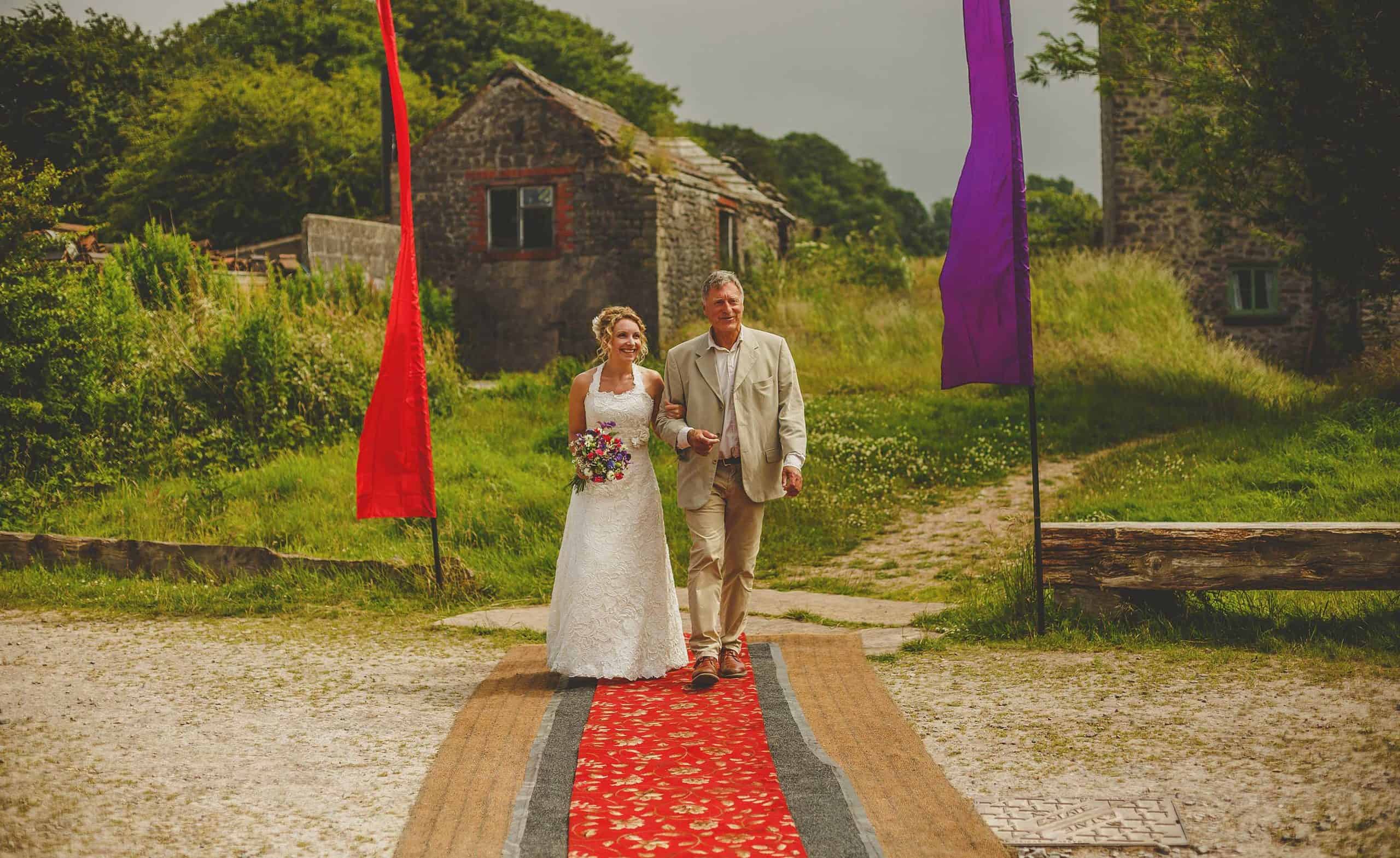 A bride and her father walk towards the outdoor ceremony at Fernhill Farm