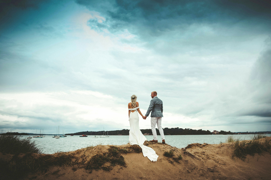Bride and groom stand overlooking a Lake